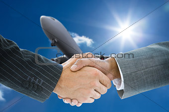 Composite image of business handshake against plane