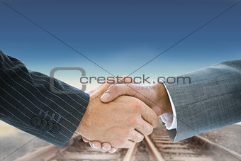 Composite image of business handshake against railway