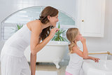 Little girl brushing teeth with mother