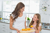 Mother looking at daughter as she picks a slice of sweet lime