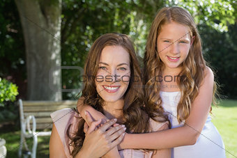 Girl embracing her mother from behind at park