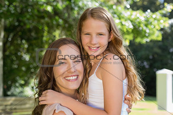 Smiling young girl and mother at park