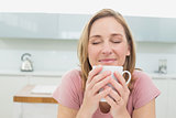 Close-up of a relaxed woman having coffee in kitchen