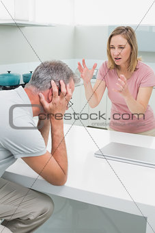 Unhappy couple having an argument in kitchen