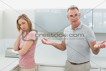 Unhappy couple having an argument in kitchen