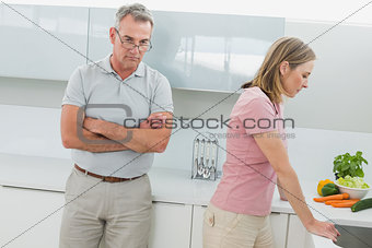 Unhappy couple not talking after an argument in kitchen