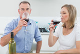 Relaxed couple drinking wine in kitchen