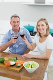 Couple toasting wine glasses in kitchen