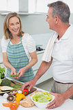 Happy couple preparing food together in kitchen