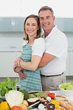 Portrait of a man embracing woman in kitchen