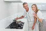 Happy couple preparing food in kitchen