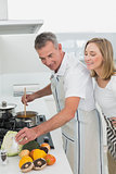Side view of a couple preparing food in kitchen