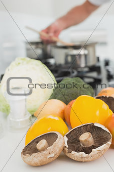 Detail of vegetables with man preparing food in background