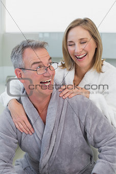 Loving couple in bathrobes in kitchen
