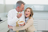 Woman embracing man while having breakfast in kitchen