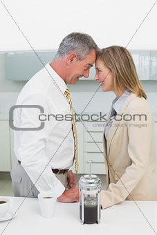 Side view of a happy business couple in kitchen