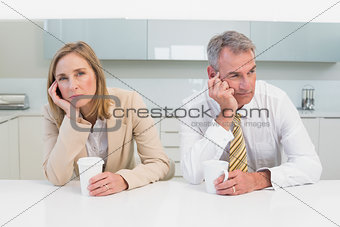 Business couple not talking after an argument in kitchen