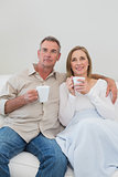 Relaxed loving couple with coffee cups in living room