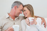 Loving couple with coffee cups in living room