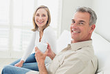 Relaxed couple with coffee cup in living room