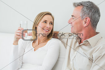 Couple with a glass of water in living room