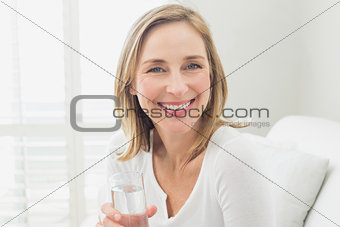 Portrait of a smiling relaxed woman with a glass of water