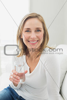 Portrait of a smiling relaxed woman with a glass of water