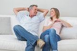 Happy relaxed couple sitting on sofa
