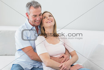 Happy couple embracing in the living room