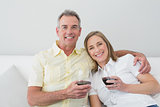 Happy couple with wine glasses sitting on sofa