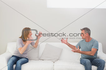 Unhappy couple having an argument in living room