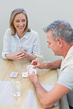 Couple playing cards at table