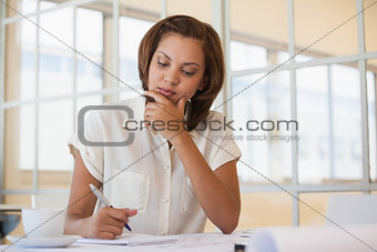 Businesswoman working on blueprint in office