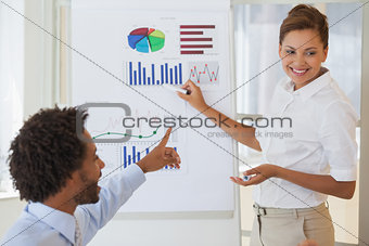 Smiling businesswoman giving presentation to colleague