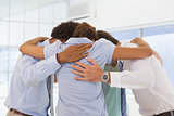 Business team with heads together forming a huddle