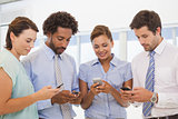 Smiling business colleagues text messaging
