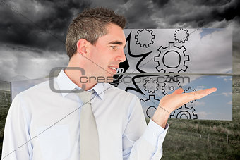 Composite image of smiling businessman looking at hand