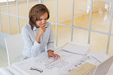 Businesswoman working on blueprints in office
