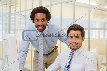 Smiling businessmen with computer in office