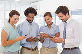 Business colleagues text messaging in office