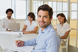 Smiling businessman with colleagues in meeting in at office