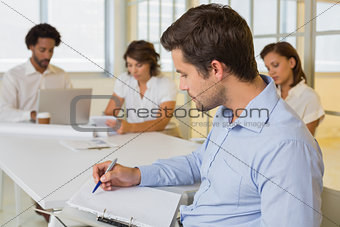 Businessman reading document with colleagues in meeting at office