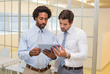 Businessmen looking at digital tablet in office