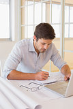 Businessman working on blueprints in office