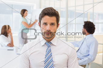 Serious businessman with colleagues in meeting at office