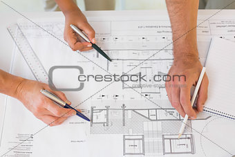 Extreme close-up of hands working on blueprints