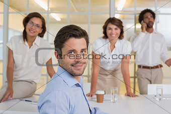 Smiling young businessman with colleagues at office
