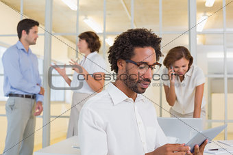 Concentrated businessman using digital table with colleagues at office