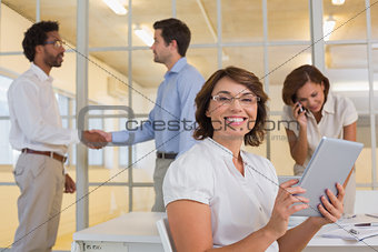 Businesswoman using digital table with colleagues at office