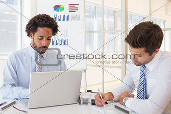 Concentrated businessmen with graph board in background